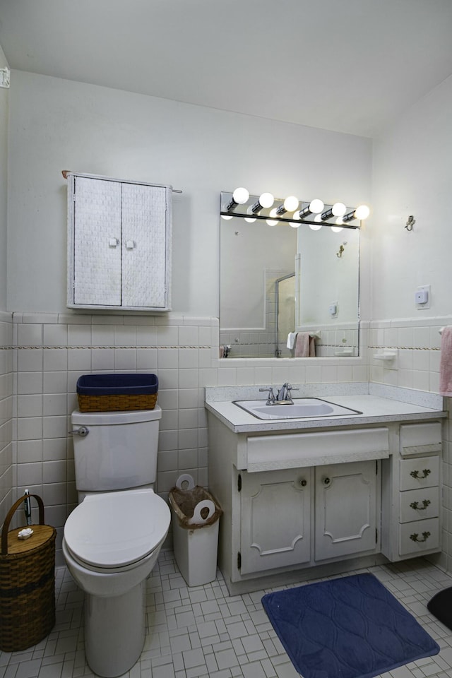 bathroom with tile walls, vanity, and toilet