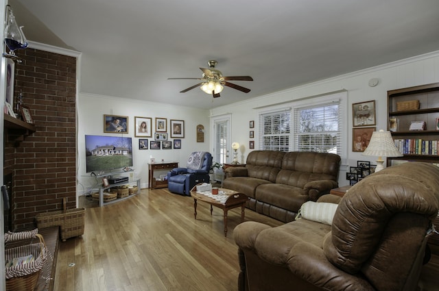 living room featuring ornamental molding, a fireplace, light hardwood / wood-style floors, and ceiling fan