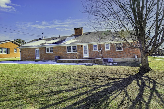 rear view of property featuring a yard and central AC