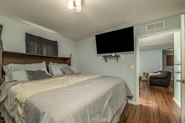 bedroom featuring hardwood / wood-style flooring and a textured ceiling