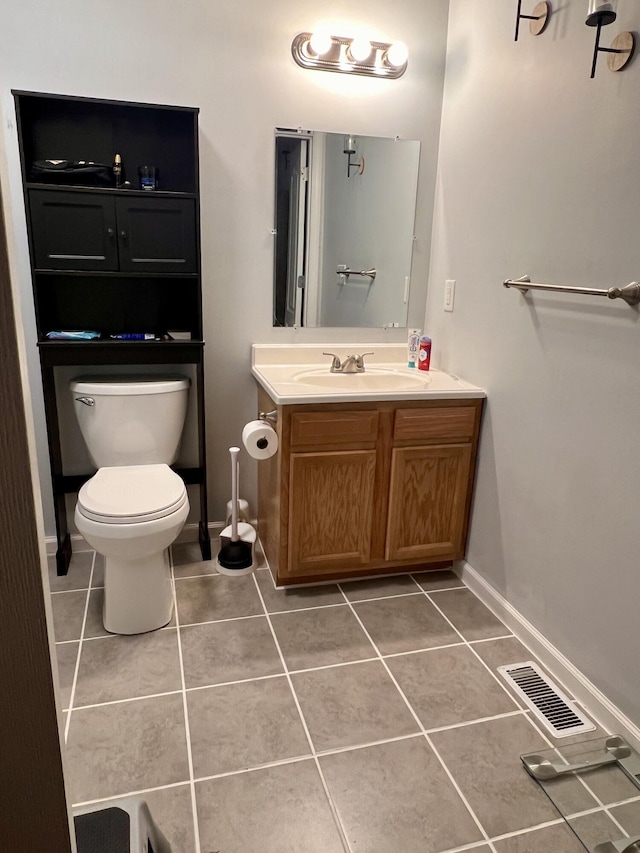 half bath with visible vents, toilet, tile patterned flooring, baseboards, and vanity