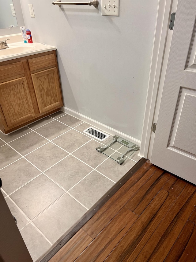 bathroom with visible vents, baseboards, wood finished floors, and vanity