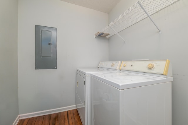 laundry room featuring washer and dryer, dark wood-type flooring, and electric panel