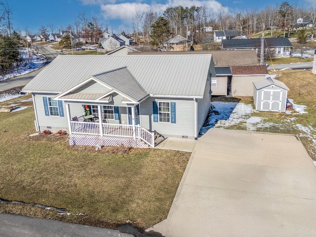 view of front facade with a storage shed, covered porch, and a front yard