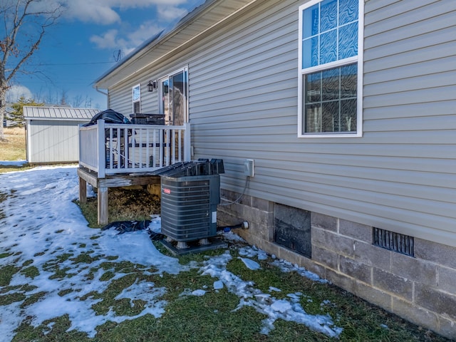 snow covered property with cooling unit