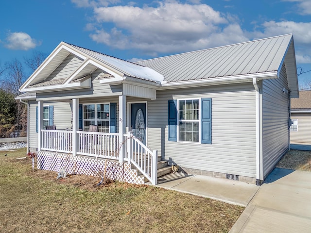 view of front facade featuring crawl space, a front yard, a porch, and metal roof