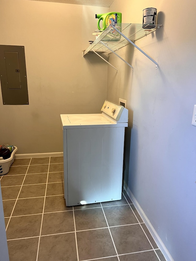 washroom featuring baseboards, laundry area, dark tile patterned flooring, electric panel, and washer / clothes dryer