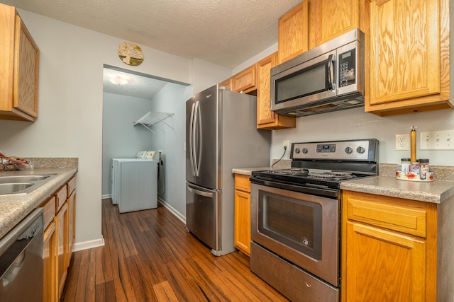 kitchen featuring sink, stainless steel appliances, independent washer and dryer, a textured ceiling, and dark hardwood / wood-style flooring