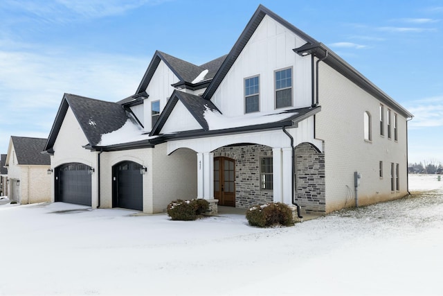 view of front of home with brick siding, board and batten siding, and an attached garage