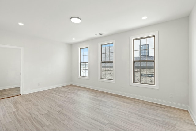 empty room with recessed lighting, light wood-type flooring, visible vents, and baseboards