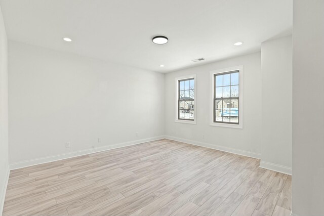 spare room featuring baseboards, recessed lighting, visible vents, and light wood-style floors