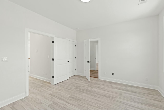 interior space with light wood-type flooring, baseboards, and visible vents