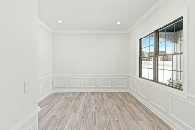 spare room with ornamental molding, recessed lighting, a decorative wall, and light wood-style flooring