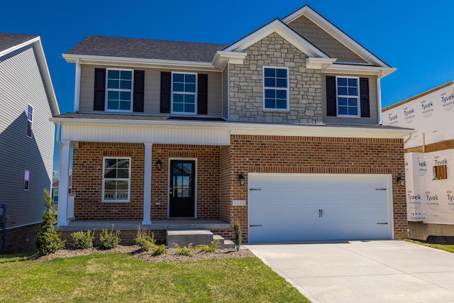 view of front of house featuring a garage, a front yard, and covered porch