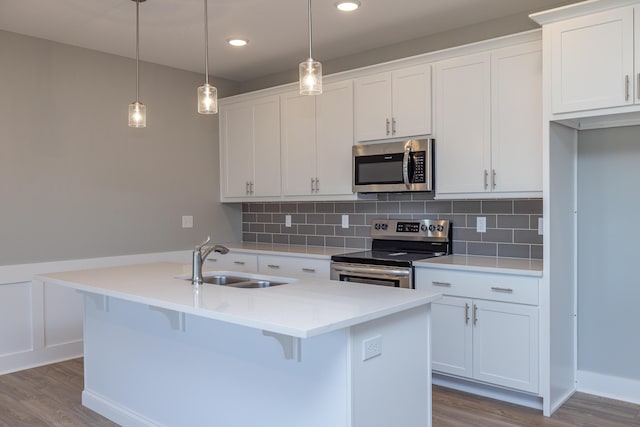 kitchen with a kitchen island with sink, white cabinetry, and appliances with stainless steel finishes