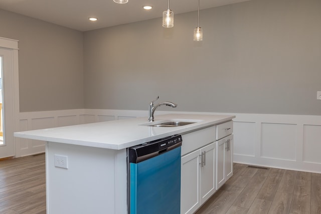 kitchen featuring dishwashing machine, pendant lighting, white cabinetry, light hardwood / wood-style floors, and an island with sink