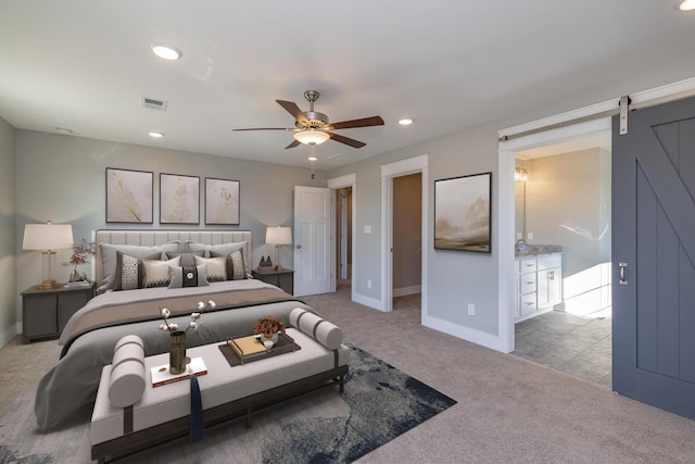 carpeted bedroom with ceiling fan and a barn door