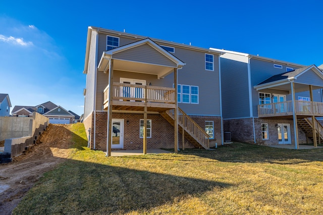 rear view of house featuring a yard, a deck, and a patio