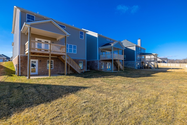 back of house featuring a wooden deck and a yard