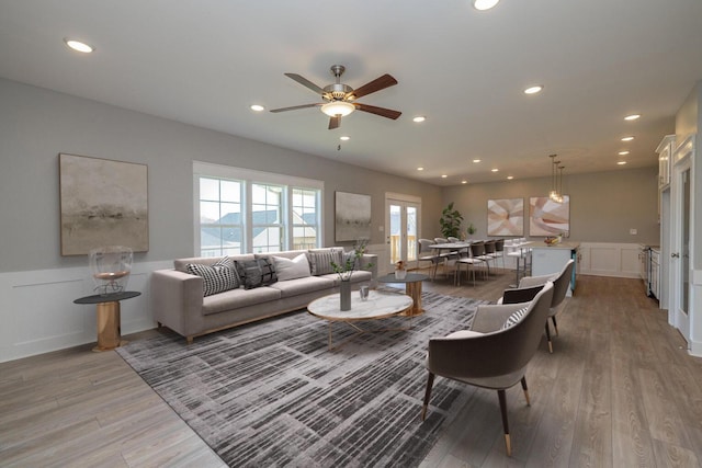 living room featuring light hardwood / wood-style flooring and ceiling fan