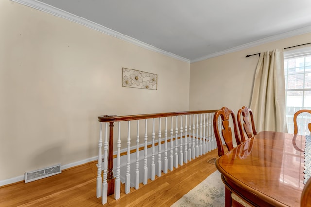 dining room with hardwood / wood-style flooring and ornamental molding