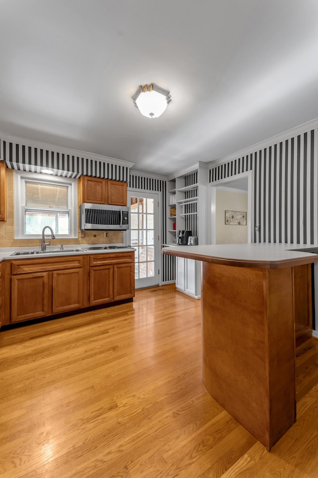 kitchen featuring sink, light hardwood / wood-style flooring, and white gas cooktop