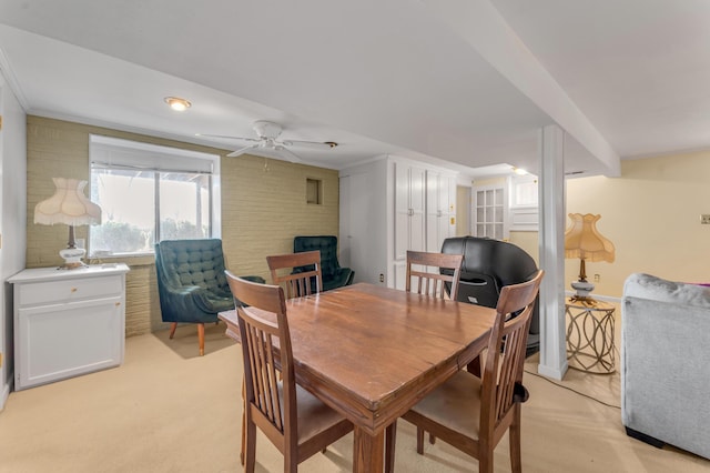 carpeted dining room featuring ornamental molding and ceiling fan