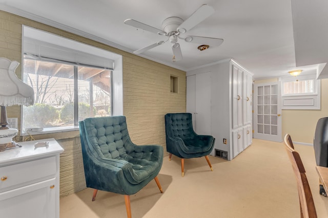 living area with brick wall and light colored carpet