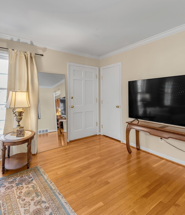 living room with crown molding and hardwood / wood-style floors