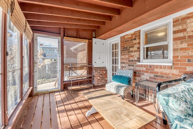 sunroom / solarium featuring beamed ceiling