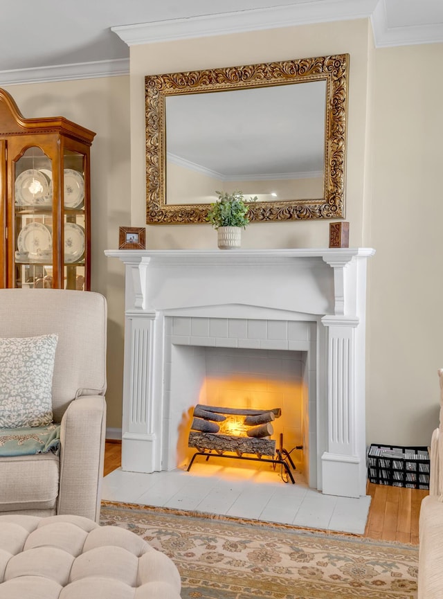 interior space with a tiled fireplace, hardwood / wood-style floors, and ornamental molding