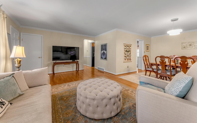 living room with crown molding and light hardwood / wood-style floors