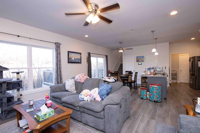 living room featuring ceiling fan, plenty of natural light, and light wood-type flooring