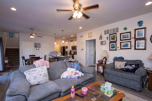 living room featuring hardwood / wood-style floors and ceiling fan