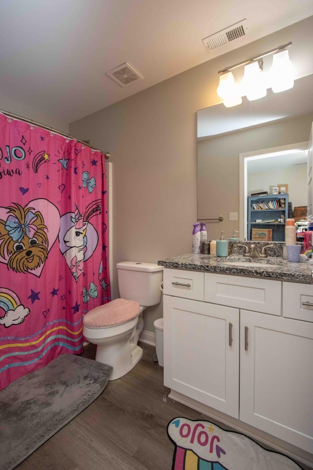 bathroom with wood-type flooring, toilet, and vanity