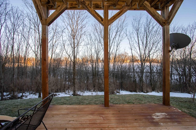 snow covered deck featuring a yard