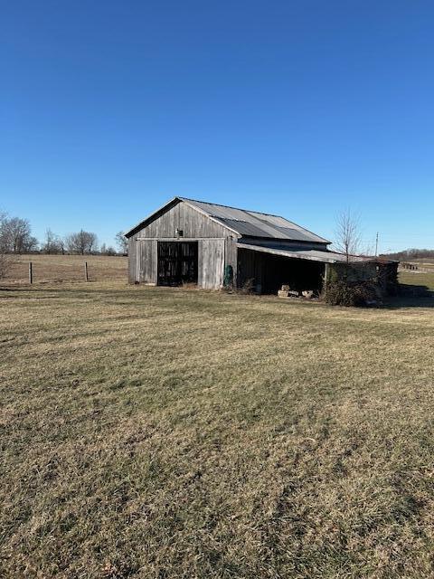 view of outbuilding with a rural view and a yard