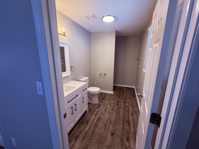 106 Liberty Ave, Berea, KY 40403 - bathroom featuring toilet, vanity, wood finished floors, a textured ceiling, and visible vents