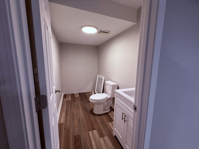 106 Liberty Ave, Berea, KY 40403 - bathroom with toilet, vanity, concrete block wall, wood finished floors, and visible vents