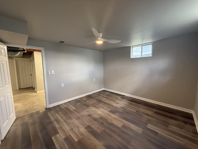 106 Liberty Ave, Berea, KY 40403 - interior space featuring visible vents, baseboards, concrete block wall, a ceiling fan, and dark wood-style floors