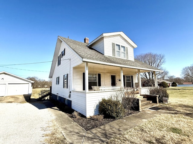 view of front facade with a garage, an outdoor structure, and a porch