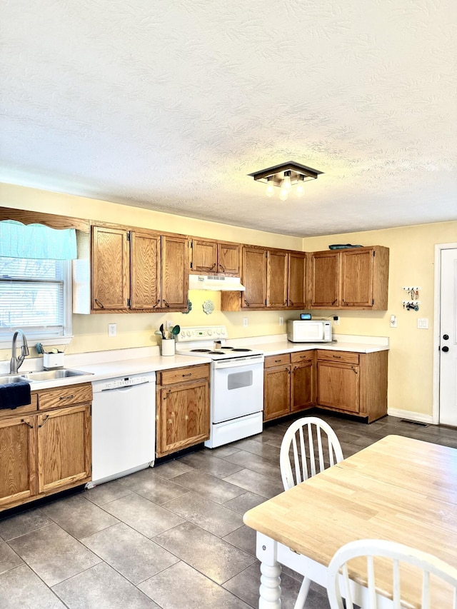 428 Columbia Ave, Monticello, KY 42633 - kitchen featuring a sink, light countertops, under cabinet range hood, white appliances, and brown cabinetry