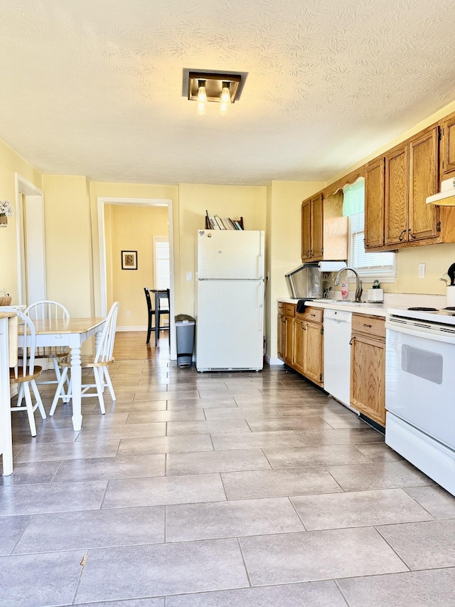 428 Columbia Ave, Monticello, KY 42633 - kitchen with white appliances, brown cabinetry, under cabinet range hood, light countertops, and a textured ceiling