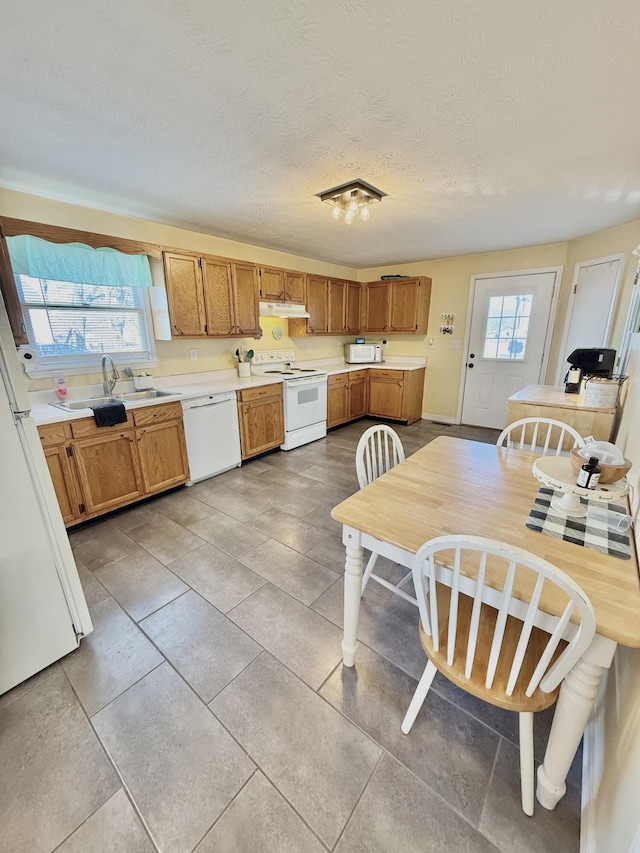 kitchen with sink, light tile patterned floors, a textured ceiling, and white appliances