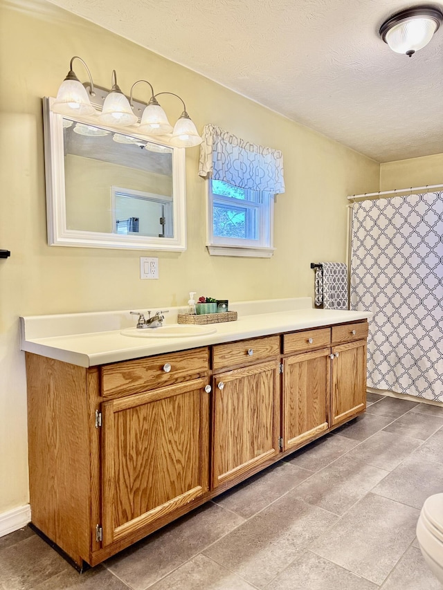 bathroom featuring vanity, toilet, and a textured ceiling