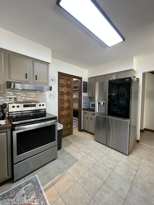 kitchen featuring tasteful backsplash, appliances with stainless steel finishes, and light tile patterned floors