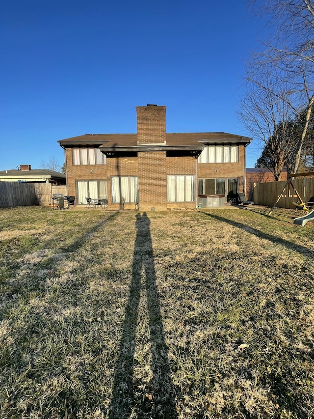 rear view of property with a lawn