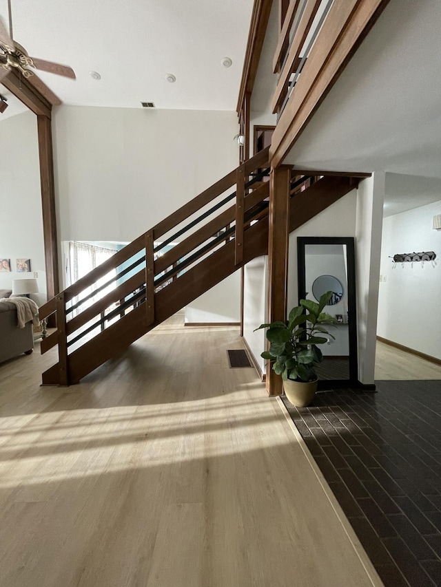 staircase featuring wood-type flooring and ceiling fan