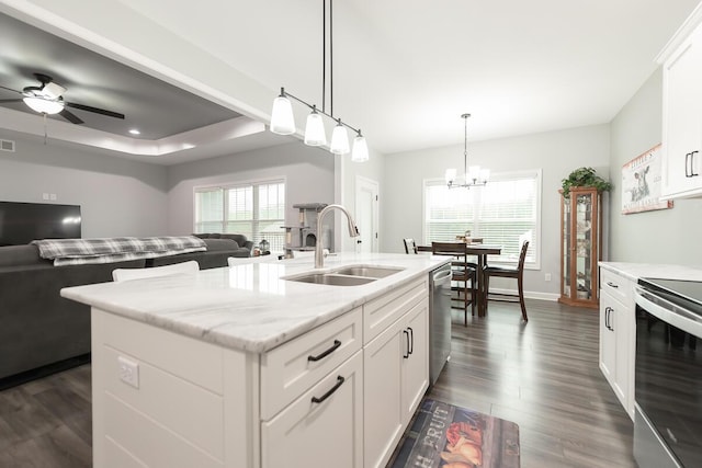 kitchen featuring stainless steel appliances, open floor plan, a sink, and dark wood-style flooring