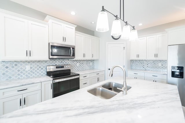 kitchen featuring white cabinetry, appliances with stainless steel finishes, backsplash, and a sink